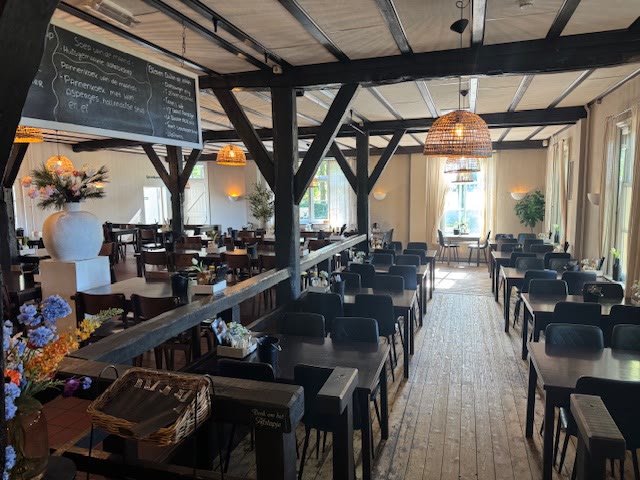 Het restaurant met houten balken en gedekte tafels